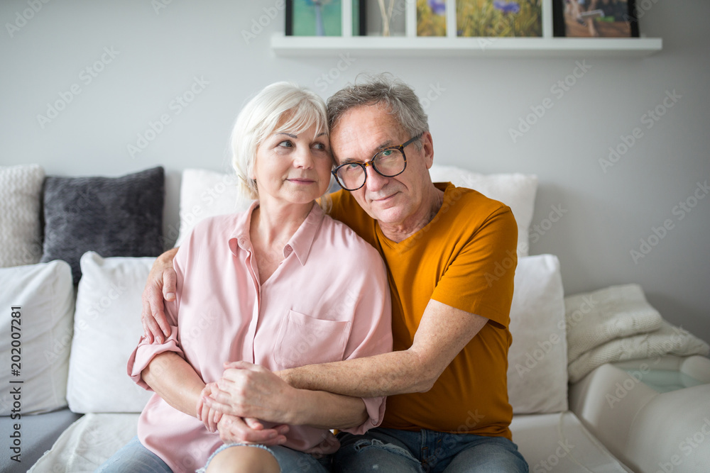 Happy senior marriage embracing together on couch Happy senior marriage embracing together on couch