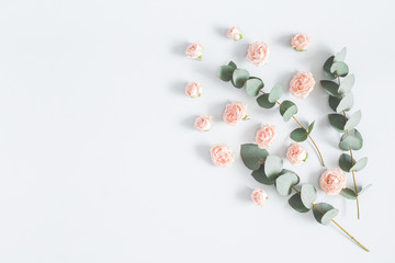 Flowers composition. Frame made of rose flowers and eucalyptus branches on pastel blue background. Flat lay, top view, copy space