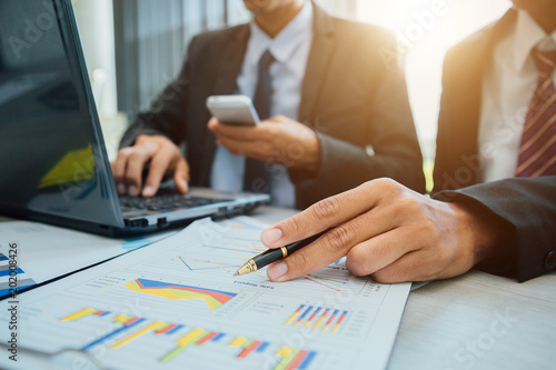 Successful team leader and business owner leading informal business meeting. Businessman working on laptop in foreground. Business and entrepreneurship concept.