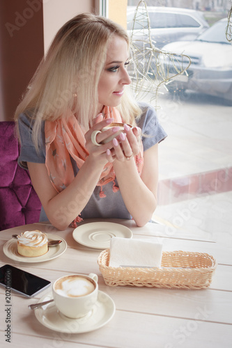 Portrait of beautiful woman in the cafe with a cup of cappuccino