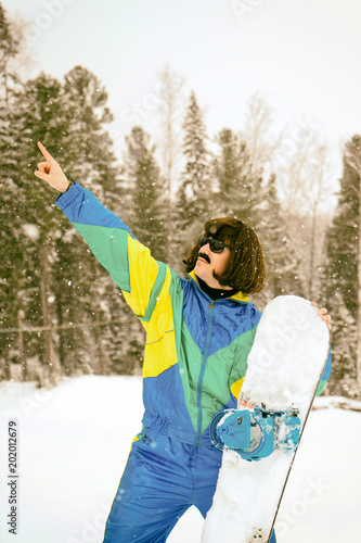 Vintage photo of young man snowboarder in the mountains. Retro style. 1980 concept.