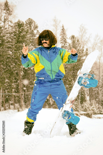 Vintage photo of young man snowboarder in the mountains. Retro style. 1980 concept.
