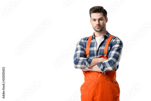 workman in orange overall standing with folded arms isolated on white