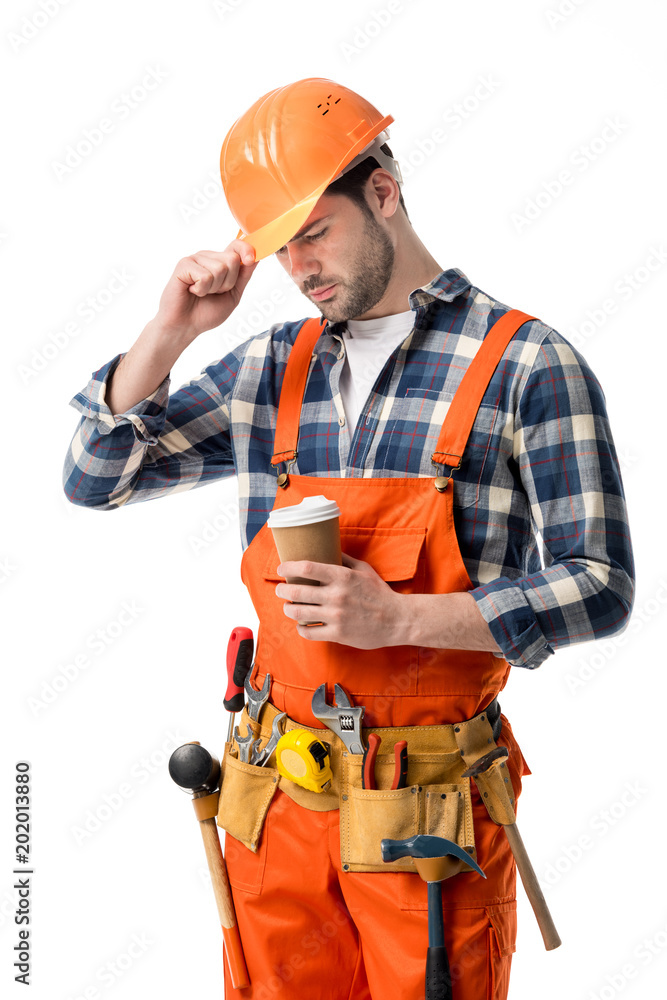 Repairman in orange overall and helmet holding coffee cup isolated on white Repairman in orange overall and helmet holding coffee cup isolated on white