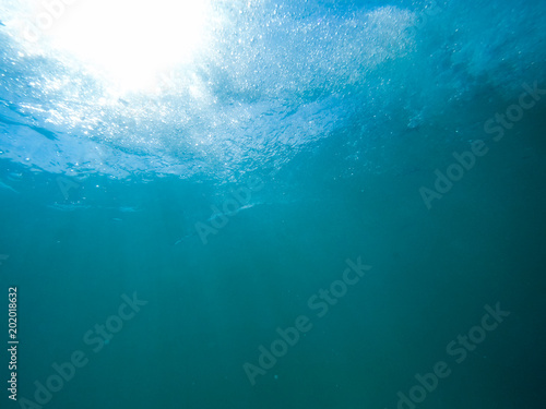 Underwater bubbles with sunlight through water surface, natural scene © Glebstock