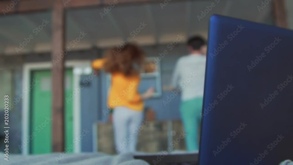 young couple surprised and shocked in front of laptop. Dancing at home in blur young couple surprised and shocked in front of laptop. Dancing at home in blur