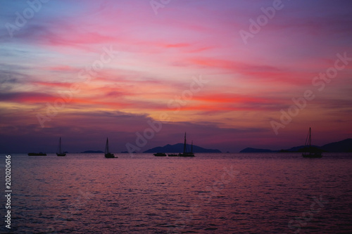 Silhouette Longtail boat with coastal fishing village,Beautiful scenery view in sunset twilight time. © snowing12