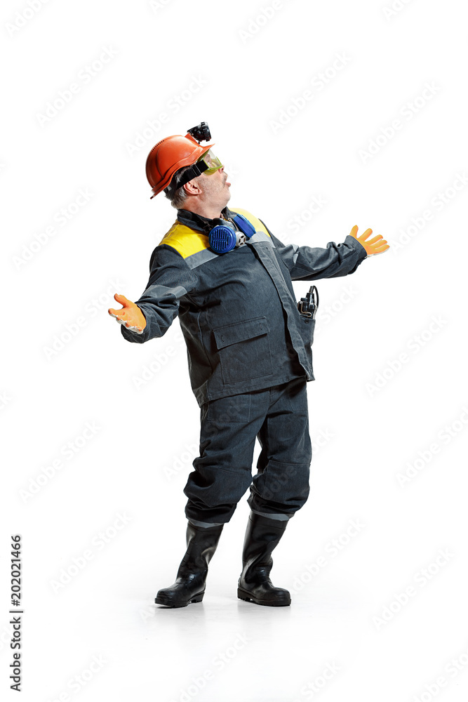 The studio shot of senior bearded male miner standing at the camera on a white background. The studio shot of senior bearded male miner standing at the camera on a white background.