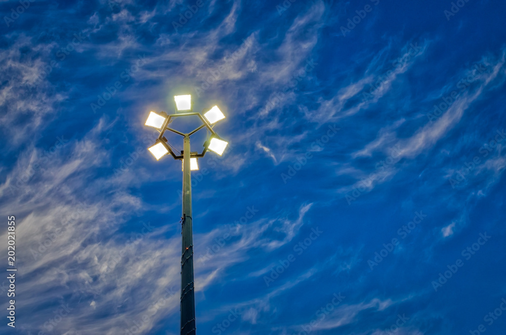 Lit hexagonal streetlight under dramatic sky. Lit hexagonal streetlight under dramatic sky.