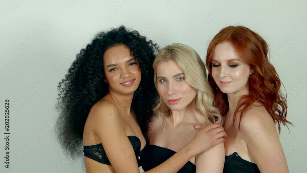 three friends with a different color curly hair dancing on the camera, women look positive and good-natured, on their faces natural makeup three friends with a different color curly hair dancing on the camera, women look positive and good-natured, on their faces natural makeup