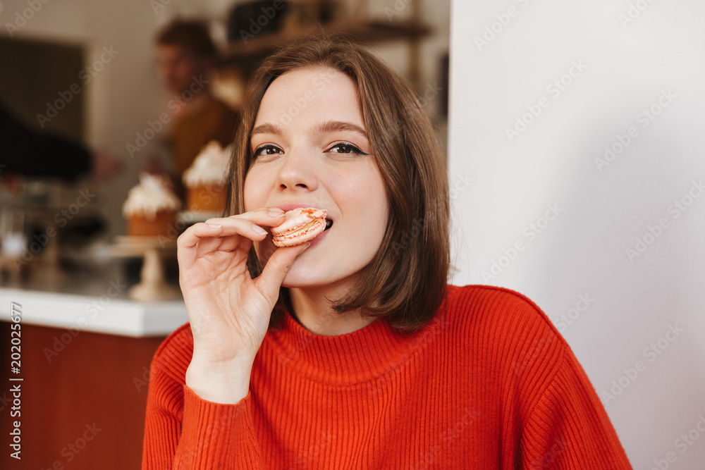 Φωτογραφία Photo closeup of brunette woman 20s in red sweater sitting in restaurant, and ea