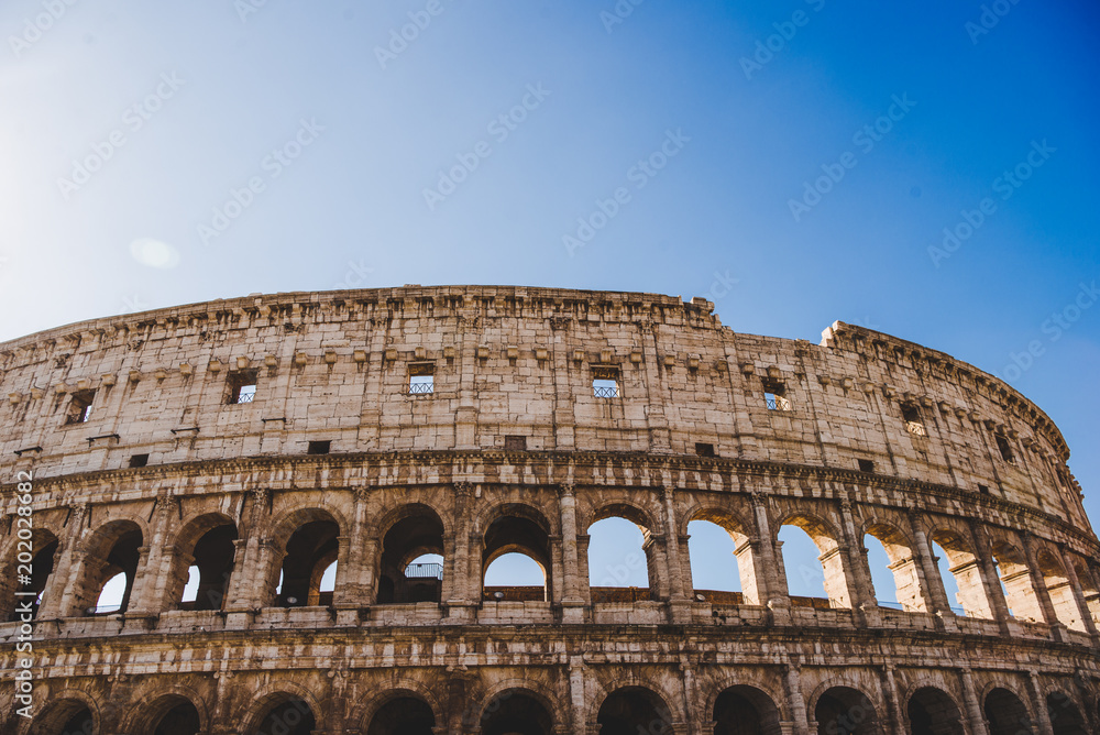 bottom view of antique Colosseum ruins in Rome, Italy