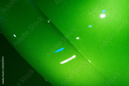 Abstract of green car front hood surface with light reflection