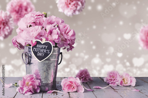 Happy mothers day letter on wood heart and pink carnation flowers in zinc bucket