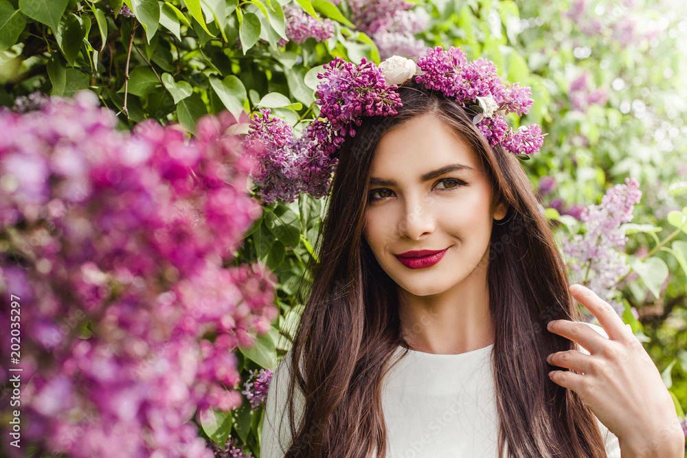 Beautiful female face with flowers. Young woman in blossom lilac flowers Beautiful female face with flowers. Young woman in blossom lilac flowers