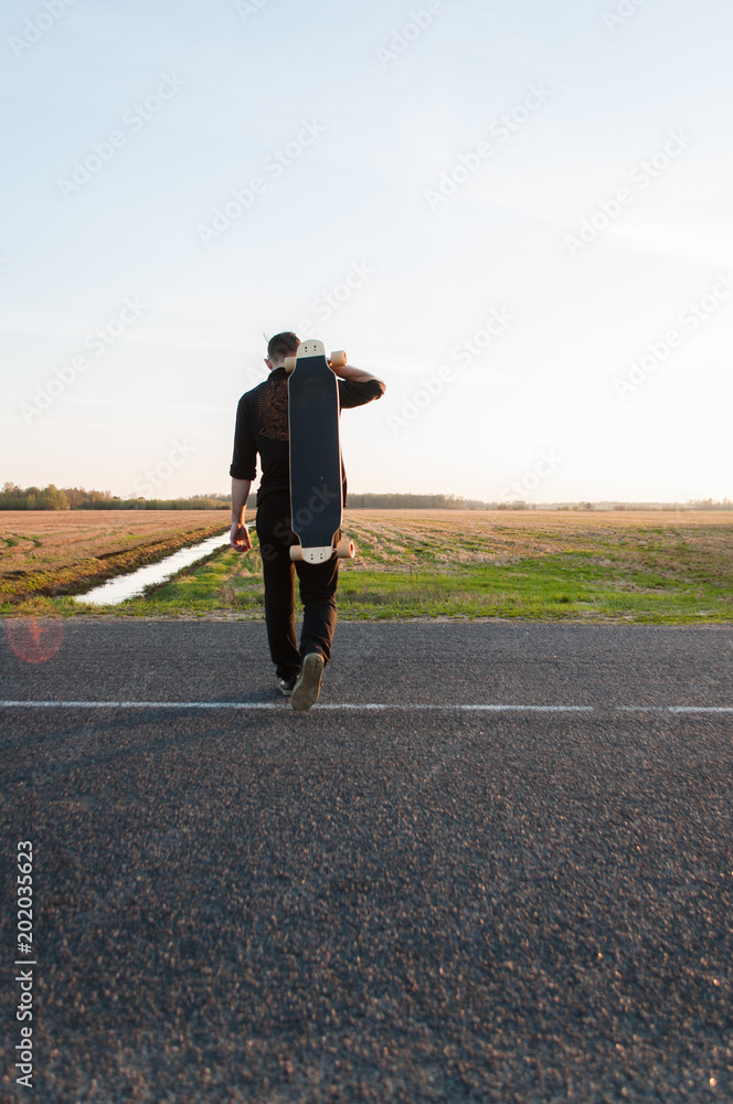 The guy with the longboard is on the asphalt, The guy with the longboard is on the asphalt,