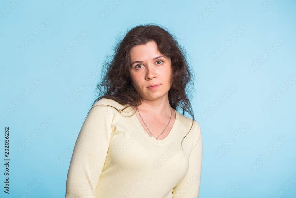 Sad and resentful woman waiting for excuses and explanations and is reproachfully looking isolated on blue background. Sad and resentful woman waiting for excuses and explanations and is reproachfully looking isolated on blue background.