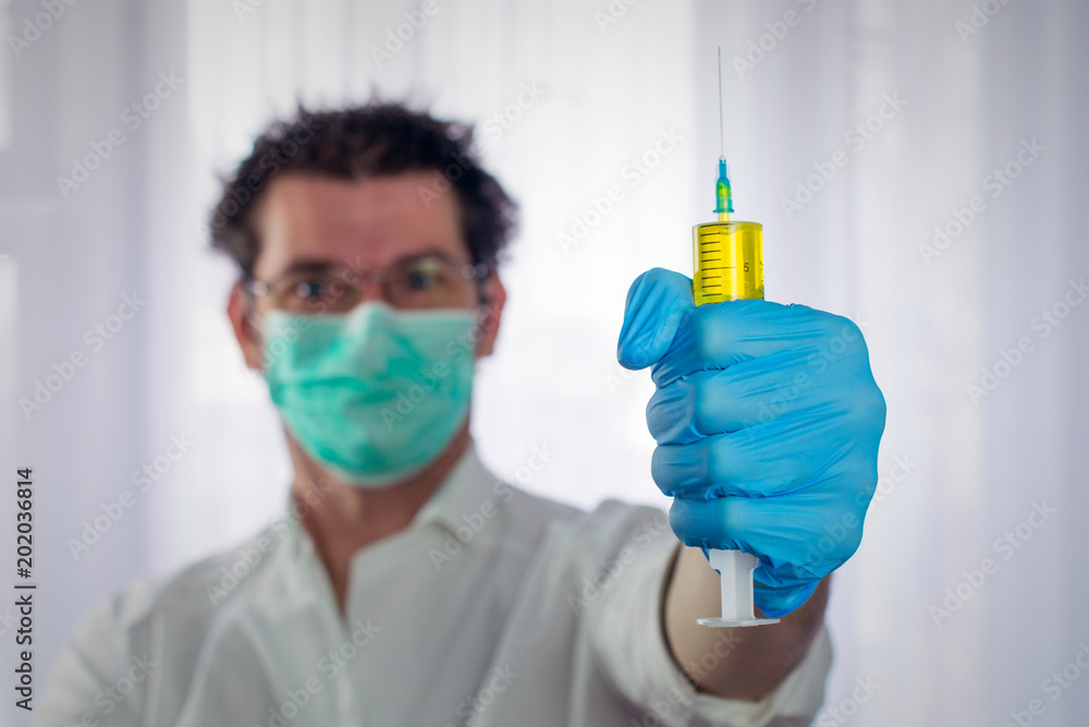 weird looking doctor holds large syringe in his hand, concept of substandard medicine weird looking doctor holds large syringe in his hand, concept of substandard medicine