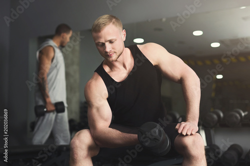 Muscular bodybuilder doing heavy deadlifts at gym