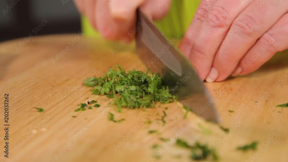 A close up shot of herb being sliced to small size. A close up shot of herb being sliced to small size.