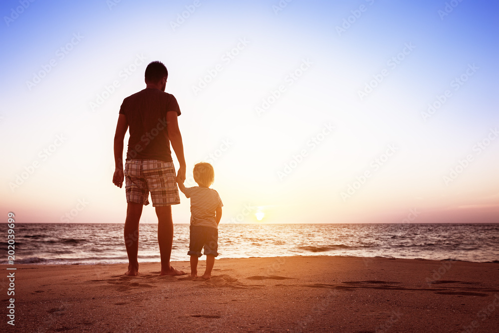 Father and son beach sunset holidays concept