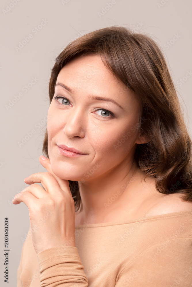 Mid age woman over 35 years old beauty concept. Close up portrait of beautiful woman gently touching her face. Isolated on white background. Mid age woman over 35 years old beauty concept. Close up portrait of beautiful woman gently touching her face. Isolated on white background.