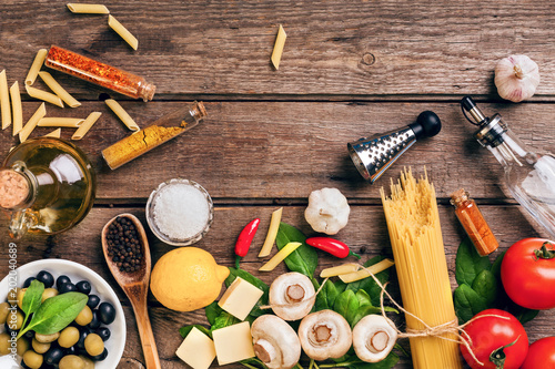 Italian food ingredients for the preparation pasta on wooden background
