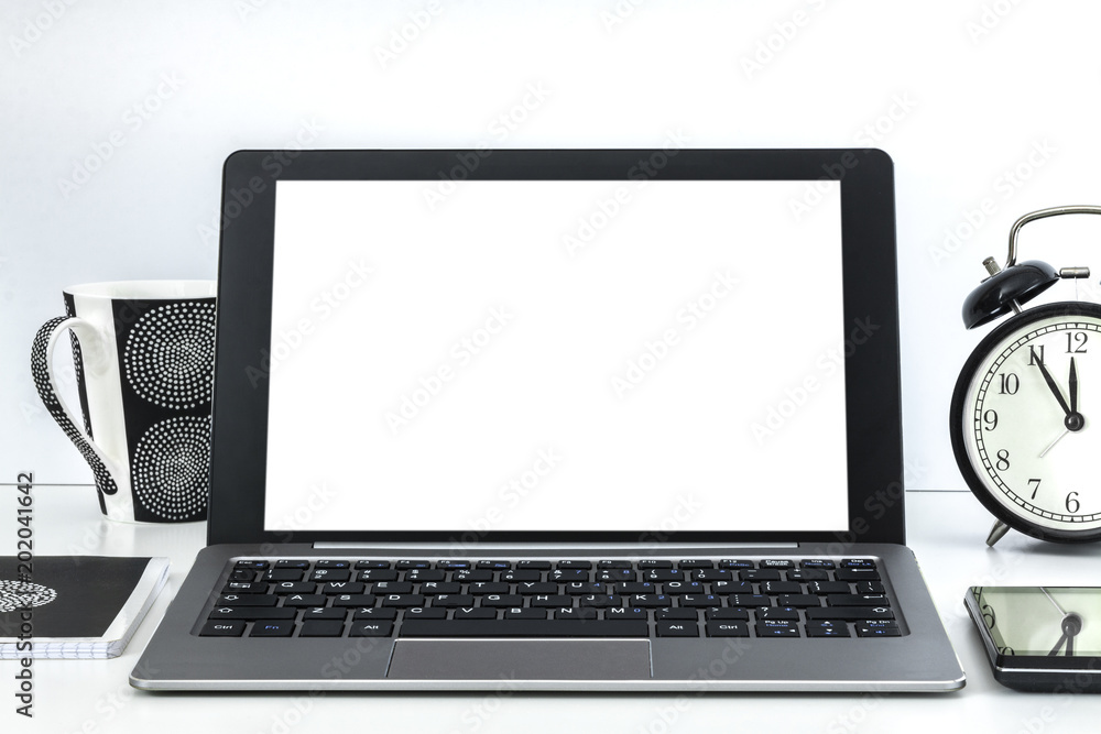 White empty desk with an open laptop, a mug of coffee and a clock White empty desk with an open laptop, a mug of coffee and a clock