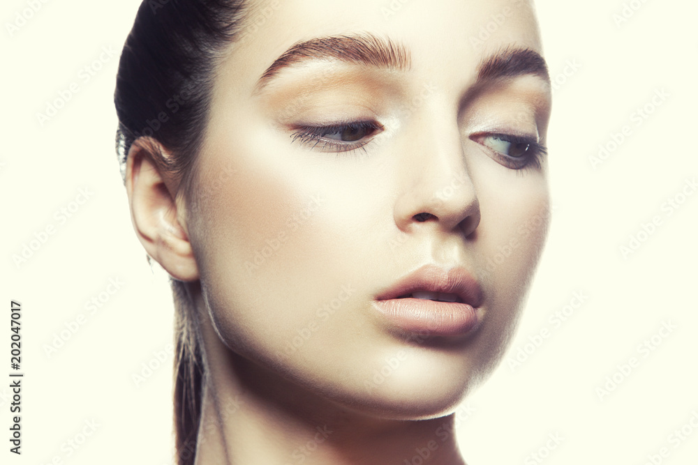 Fototapeta premium Close-up beautiful face of model girl with perfect nude make-up and natural lips, clean skin, brows. 