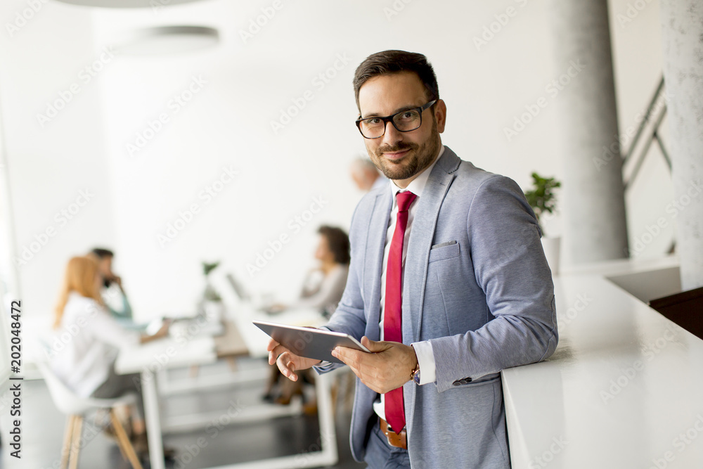 Young businessman with digital tablet in office Young businessman with digital tablet in office