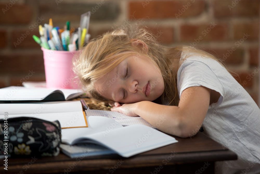 Girl tired and sleeping when doing his homework.
Girl tired and sleeping when doing his homework.