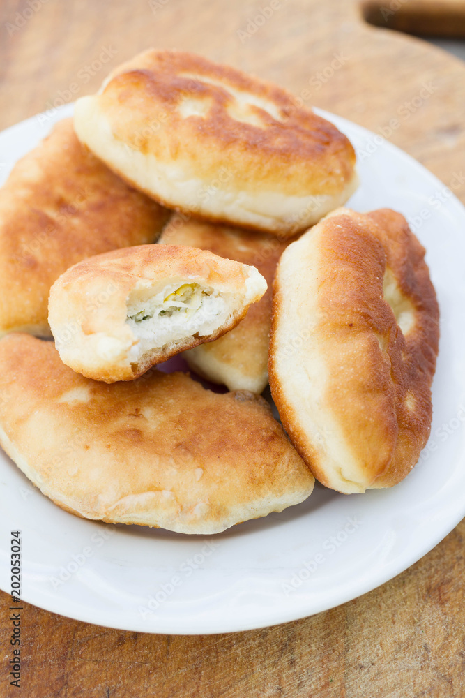 Fresh baked pastries filled with vegetables and cheese on wooden backgroun Fresh baked pastries filled with vegetables and cheese on wooden backgroun
