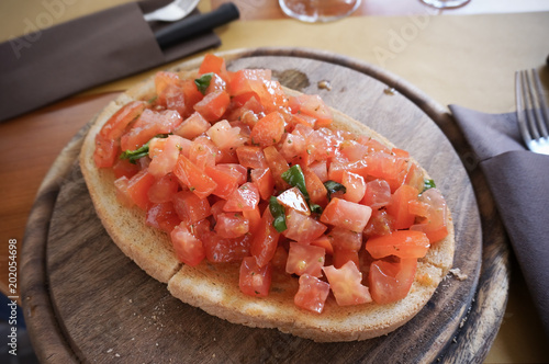 traditoinal italian dish Bruschetta served on wooden board in restaurant photo