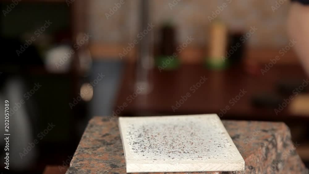 The man punches the holes in the leather blank with a hammer and a special tool The man punches the holes in the leather blank with a hammer and a special tool