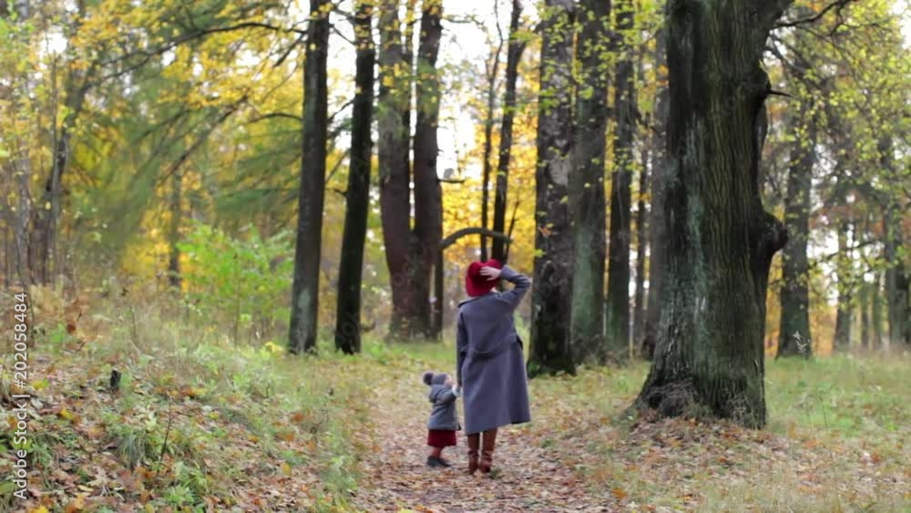 Mom and daughter are walking in the autumn park Mom and daughter are walking in the autumn park