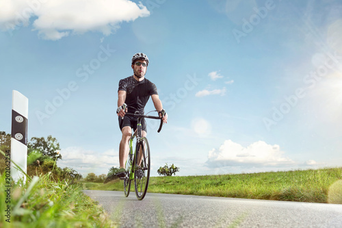 Sportlicher Radfahrer auf einer sonnigen Landstraße