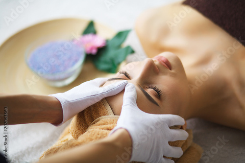 Masseur doing massage the head of an woman in spa salon