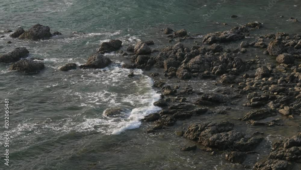 aerial view of sea tide wave splashing against rock shore. aerial view of sea tide wave splashing against rock shore.