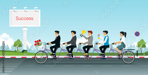 Group of business people together riding a Tandem bike with a trophy in hand.