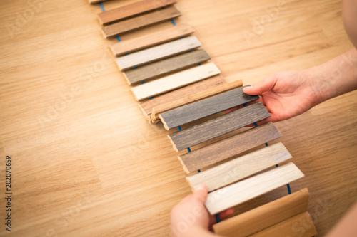 Woman chosing right flooring for her new apartment, floor sampler