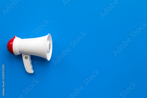 Attract attention concept. Megaphone on blue background top view copy space