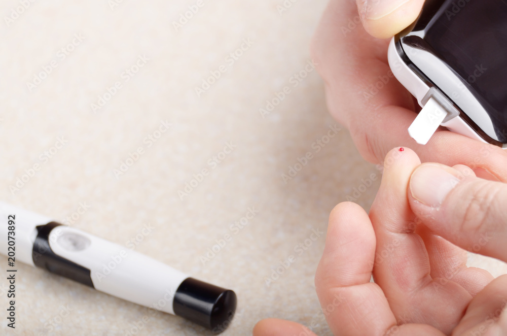 Fototapeta premium Man doing blood test with personal glucometer