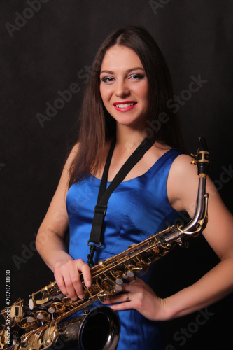 Улыбающаяся девушка с саксофоном.