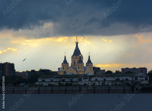 Alexander Nevsky cathedral in Nizhny Novgorod Russia. Stormy sky at sunset. View through the river