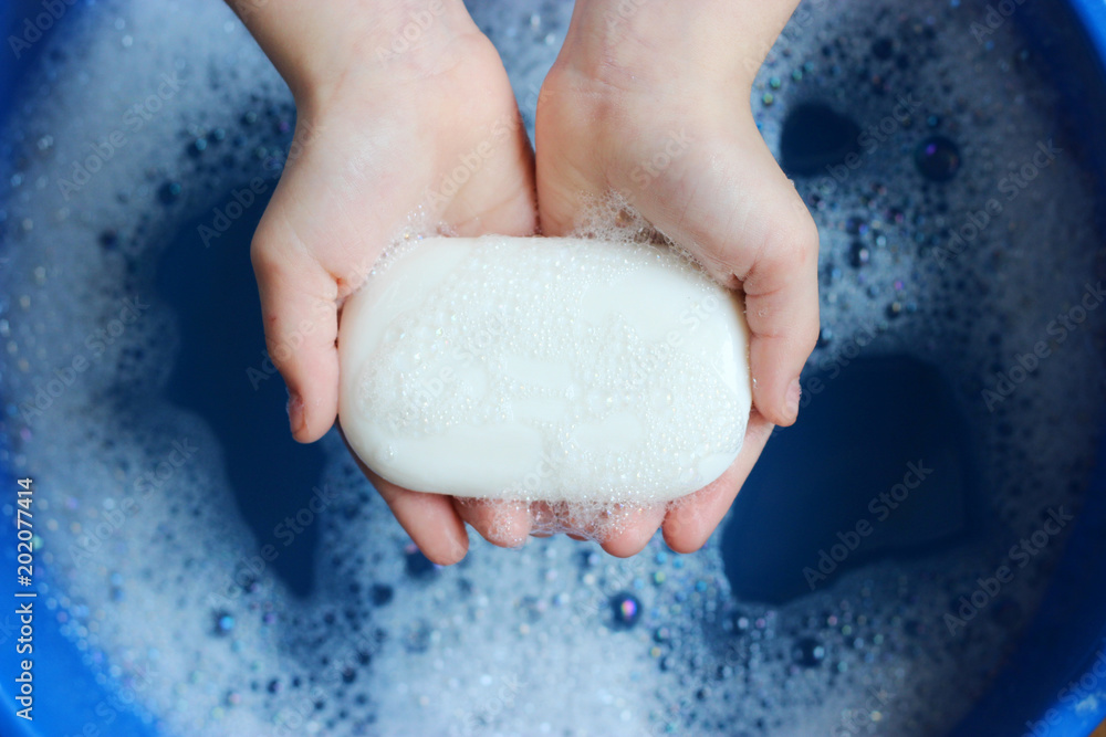 Fototapeta premium soap and soap foam in children's hands on a beautiful blue background. to wash hands. children's hygiene. hand hygiene. 