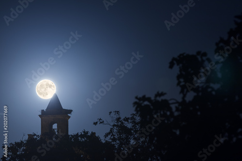 Bell tower of church with super moon photo