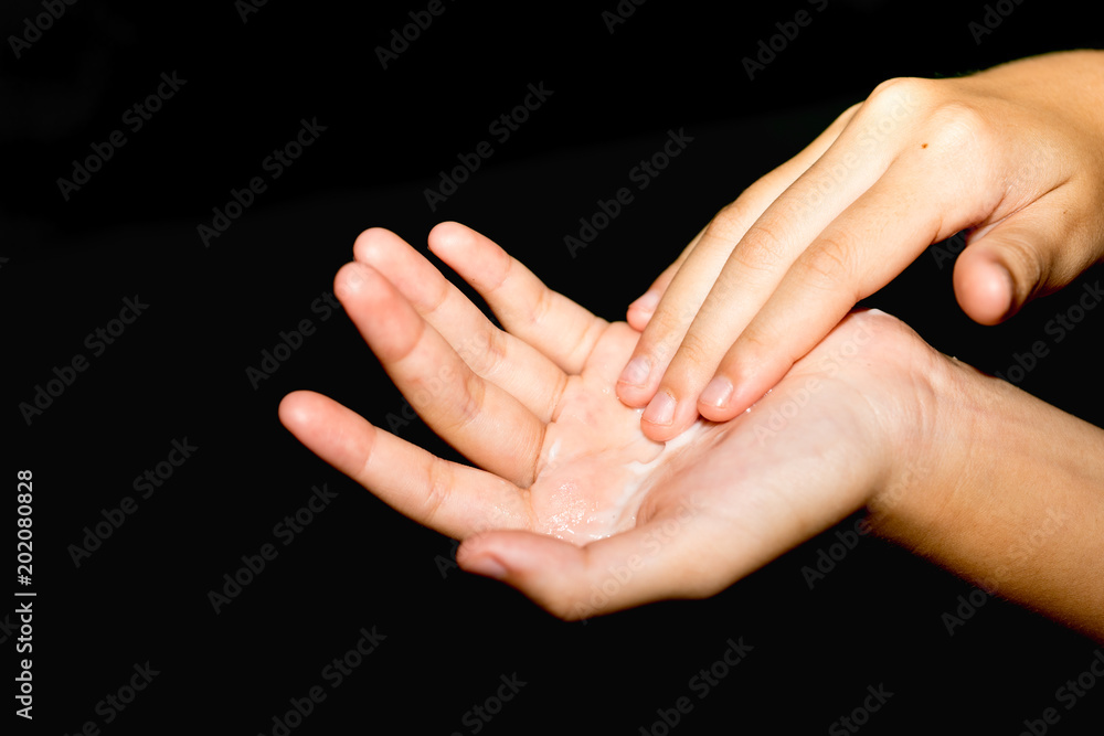 Φωτογραφία Closeup of female hands applying cream on her arm