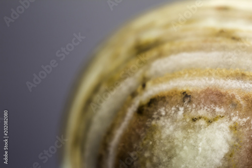Fototapeta Naklejka Na Ścianę i Meble -  Macro photo texture of polished onyx stone on a gray background. Photo for the site about geology, stones, jewelry, handwork, textures,art, astronomy.