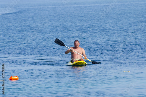 Kayak. Men kayaking in the sea near. Activities on the water.