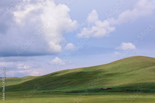 green hills under blue sky